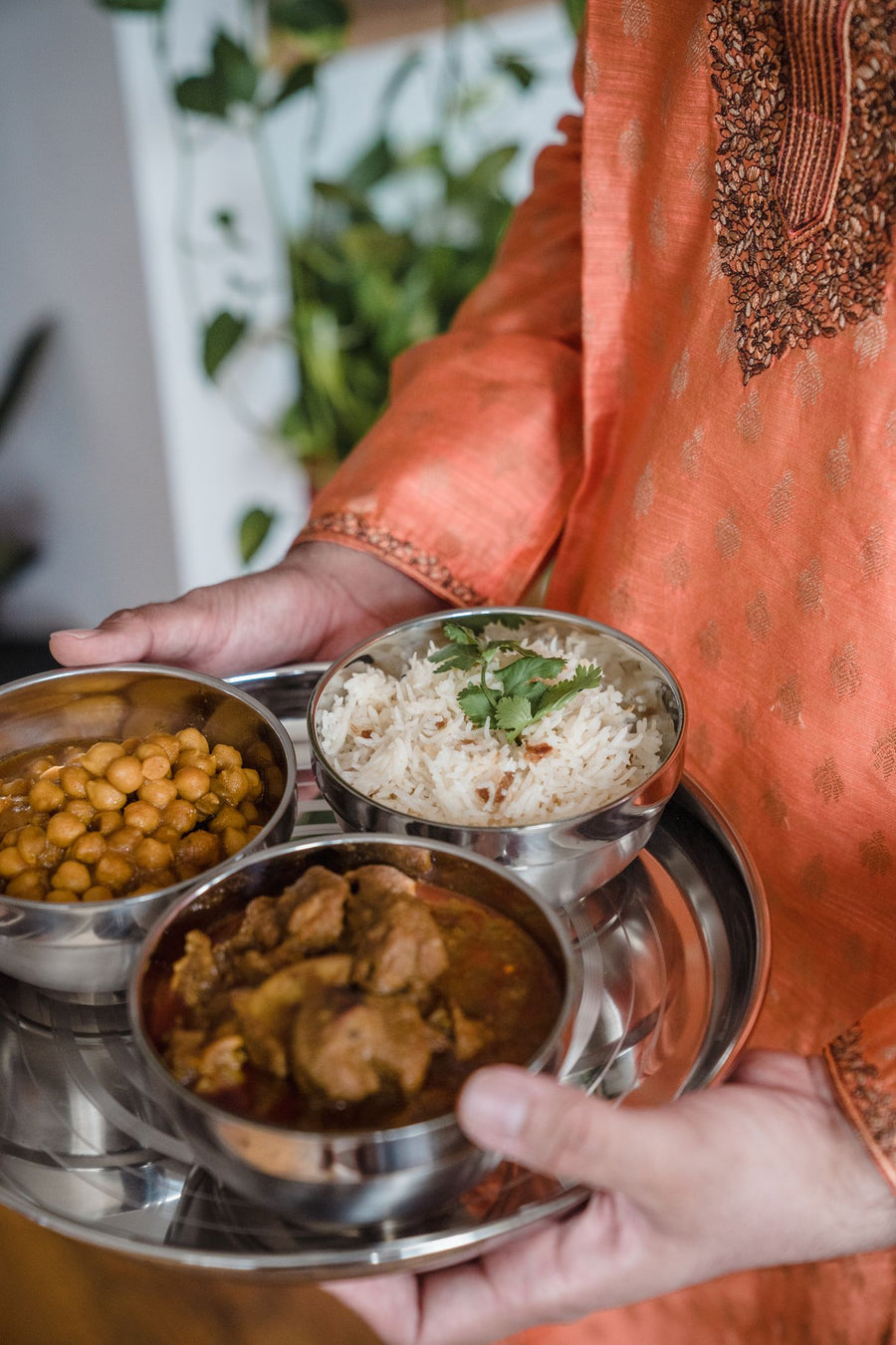 An Indian meal of rice, chickpeas and curry in steel bowls