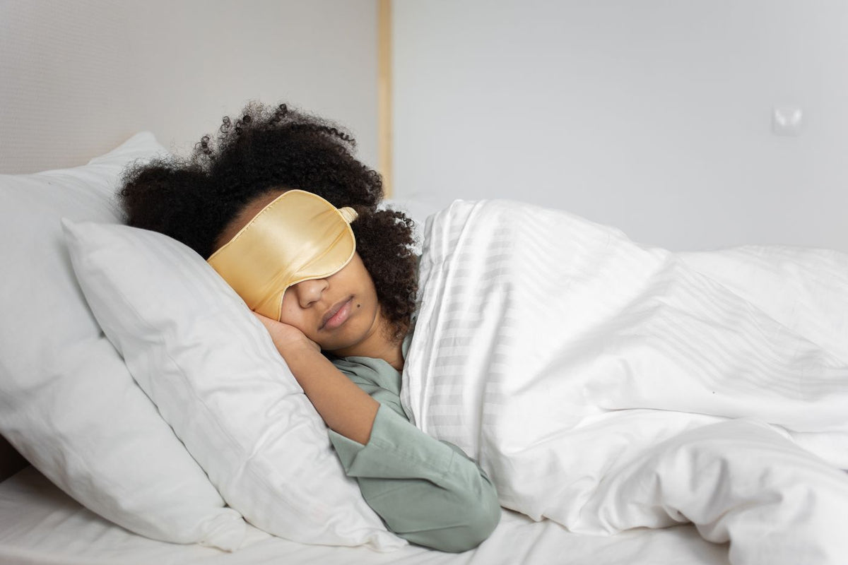 A woman sleeping with an eye mask