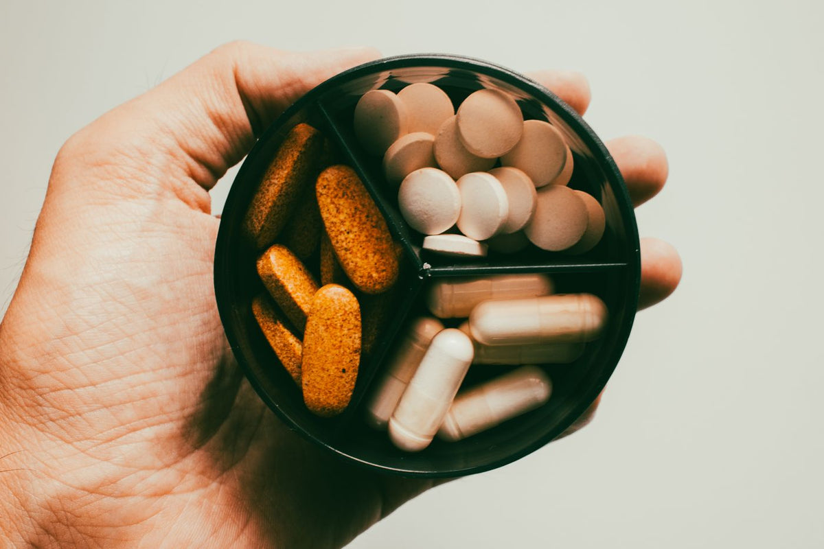 A handful of supplement capsules and tablets