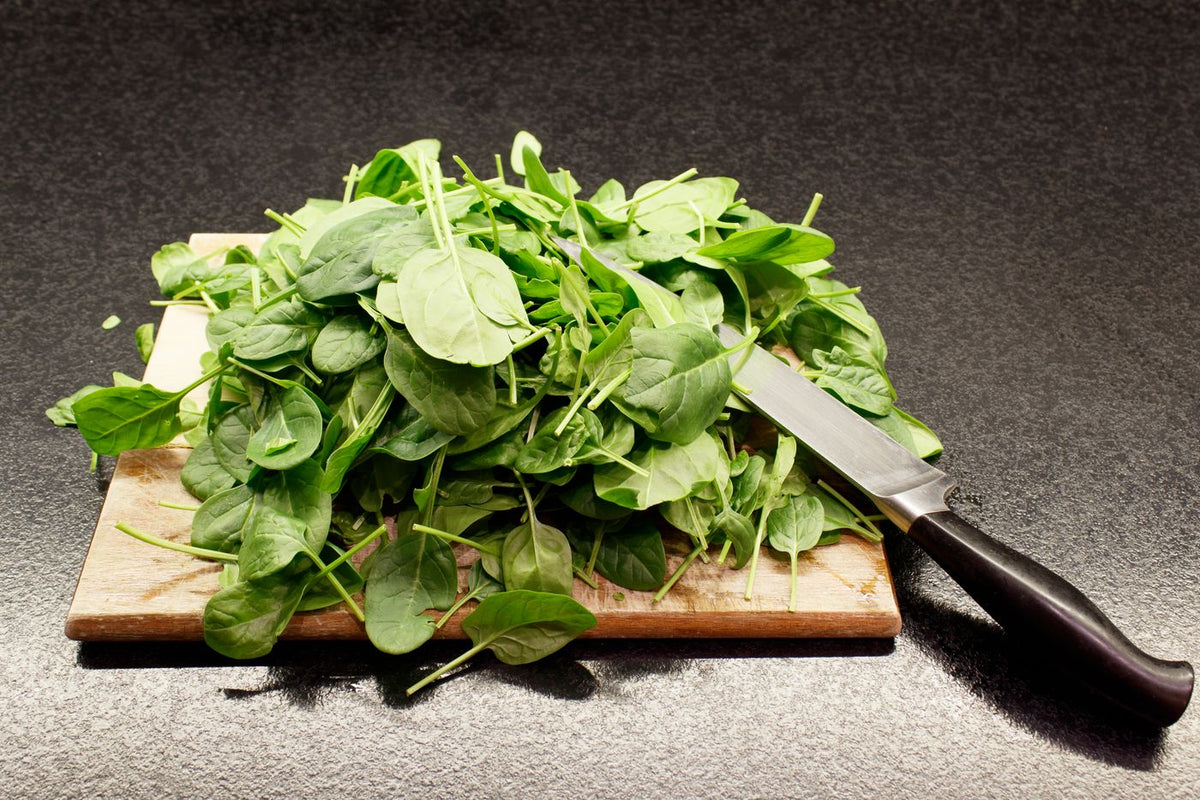 Fresh spinach (palak) leaves on a cutting board