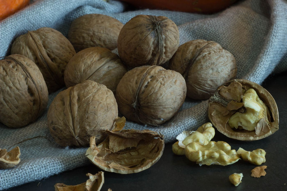 Whole and cracked walnuts on a rustic cloth