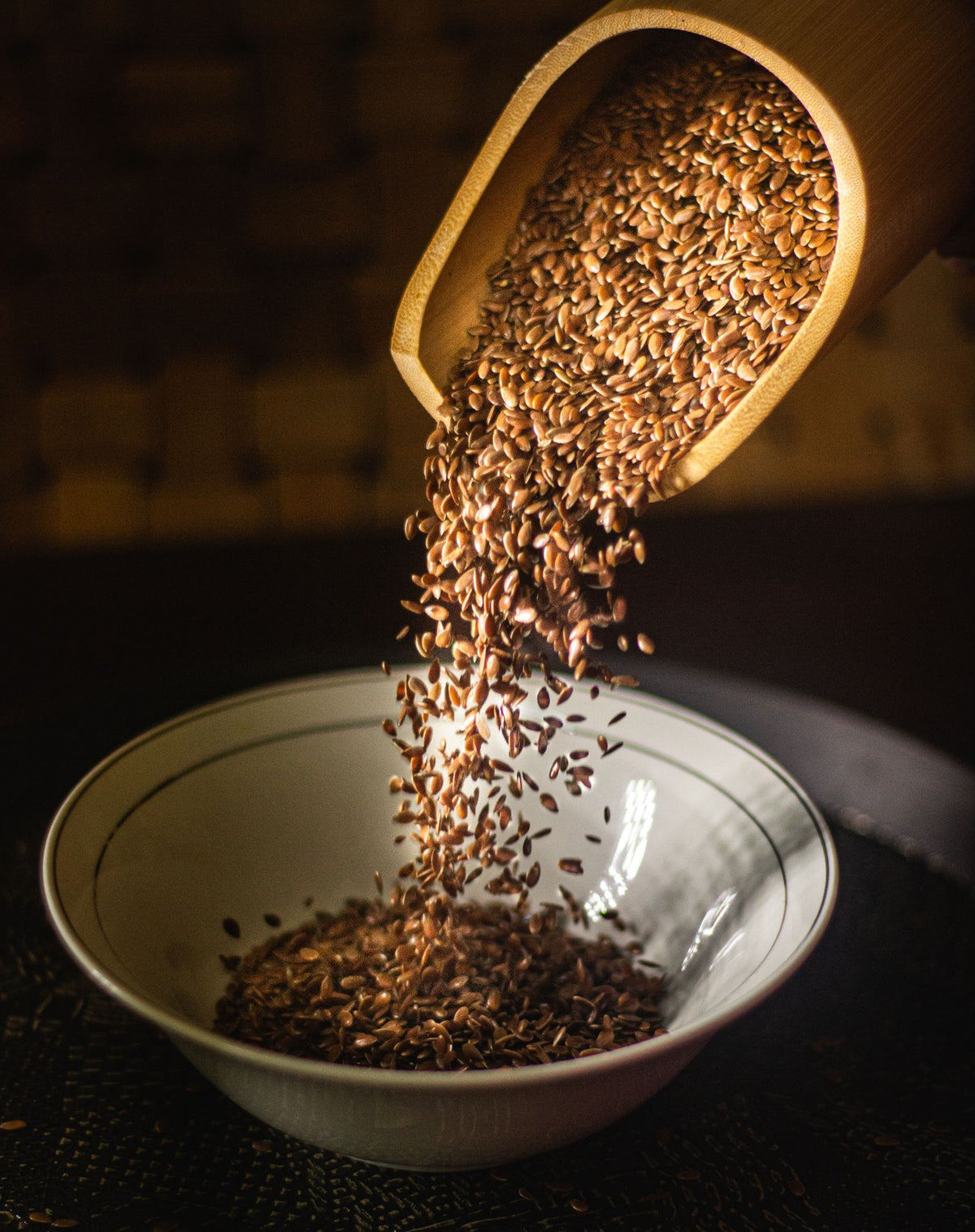 Flax seeds (alsi) being poured into a bowl