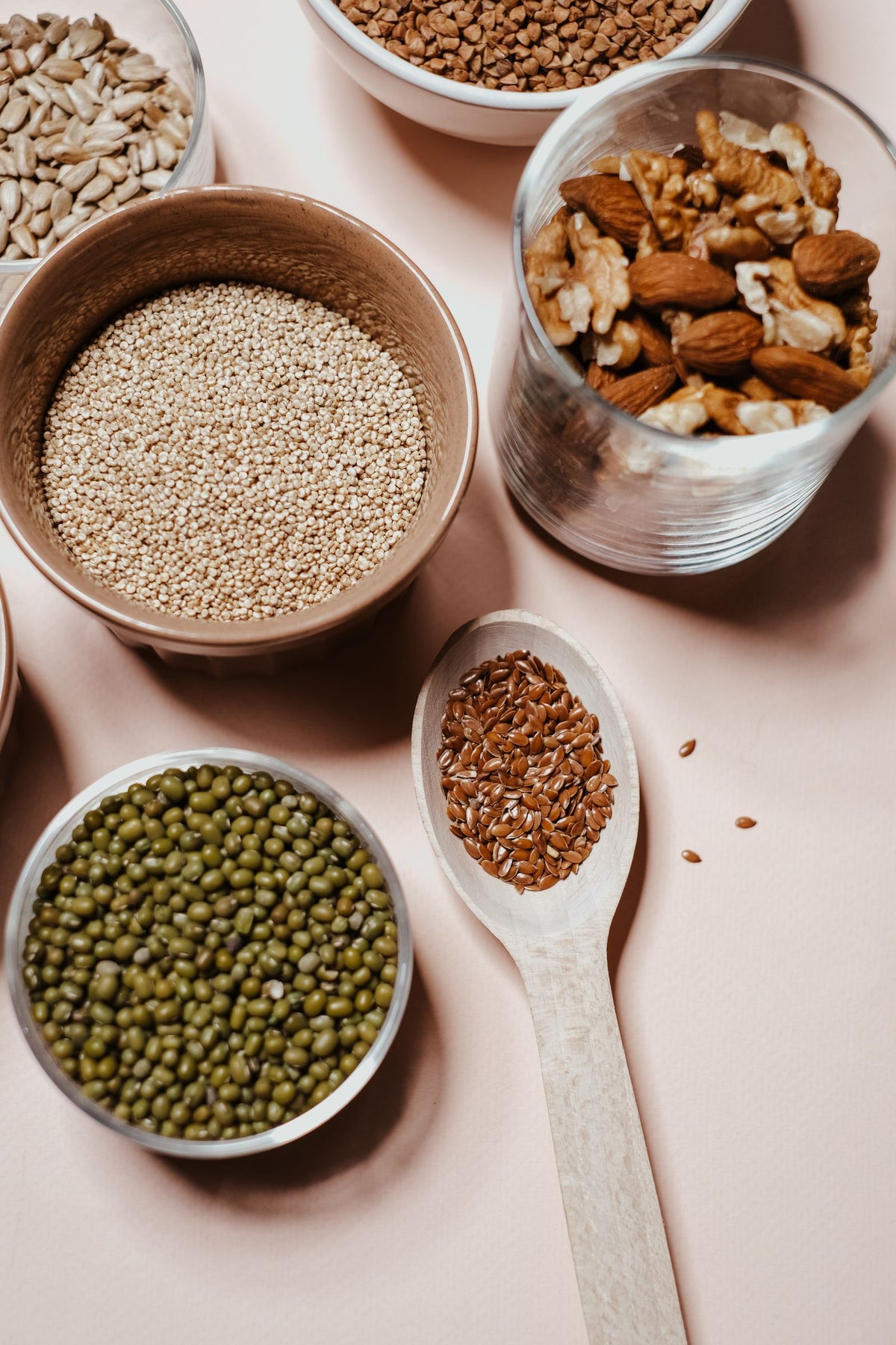 Seeds, nuts and whole moong in bowls and spoons