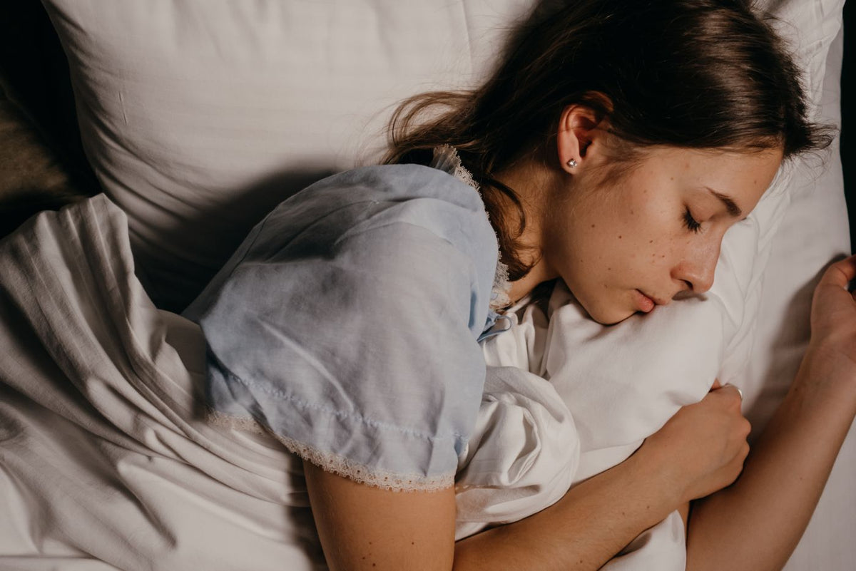A woman sleeping peacefully on a white pillow