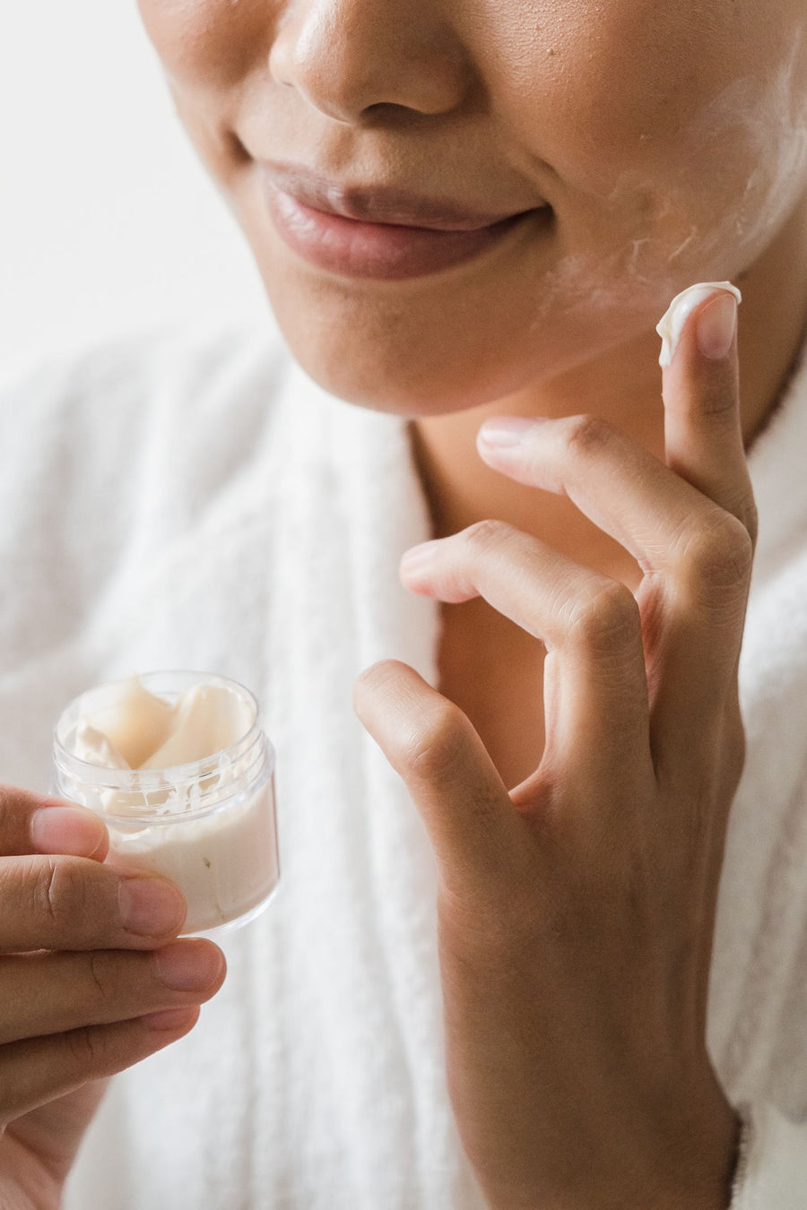 Close-up of fingers taking face cream from a jar
