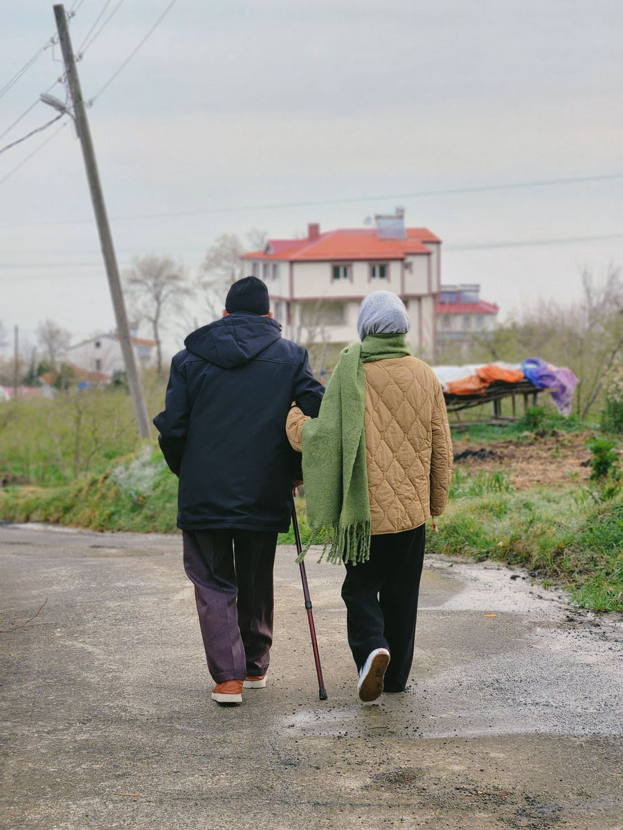 An elderly couple walking on a country road