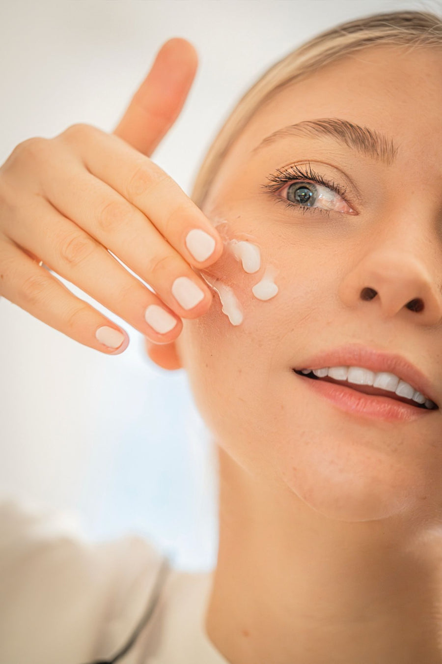 A woman applying moisturiser