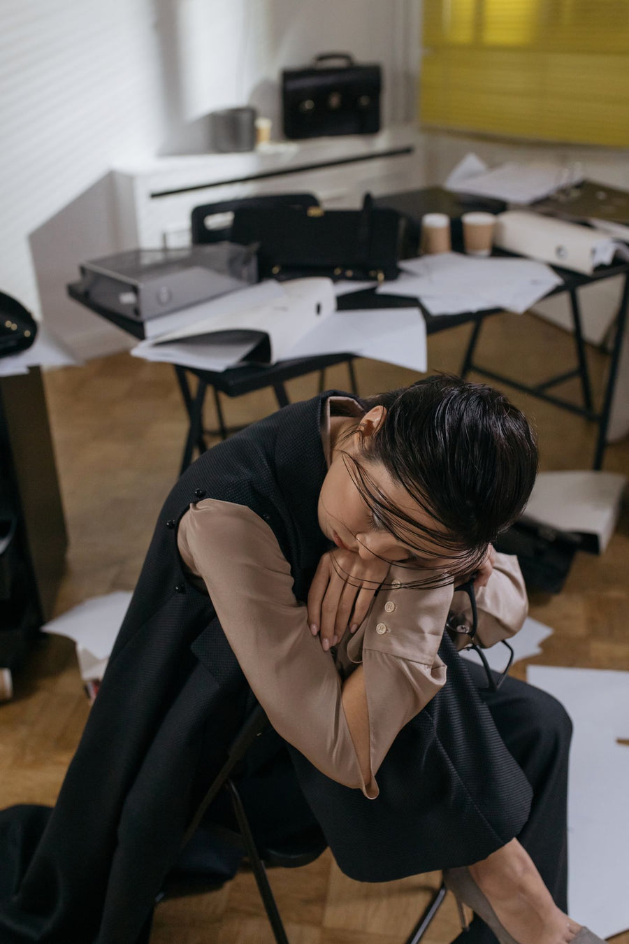 A tired woman leaning on her desk