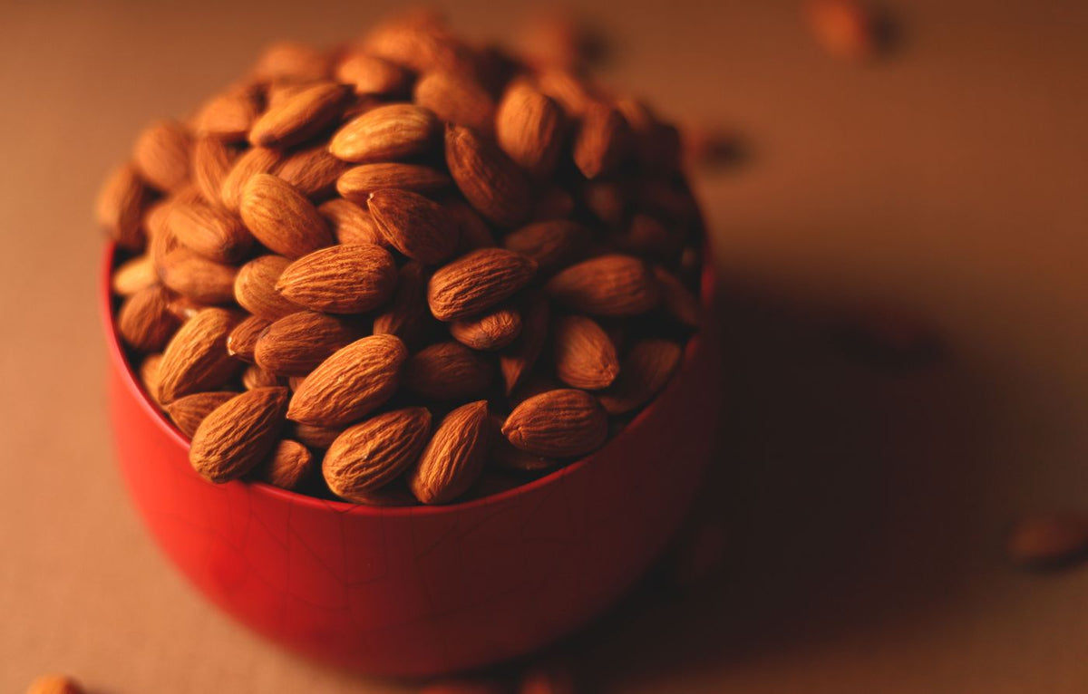 Almonds (badam) in a red bowl