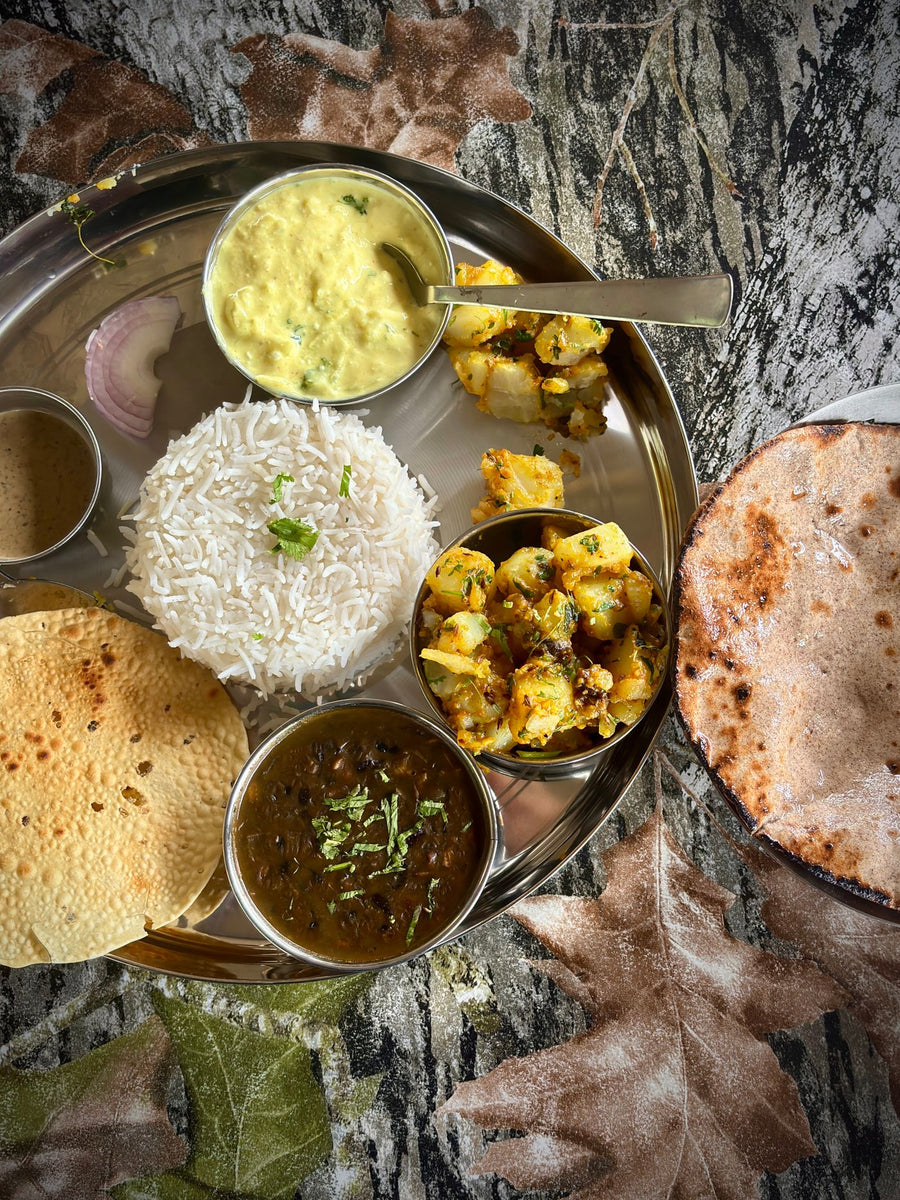 A vegetarian Indian thali with rice, dal, sabzi and roti