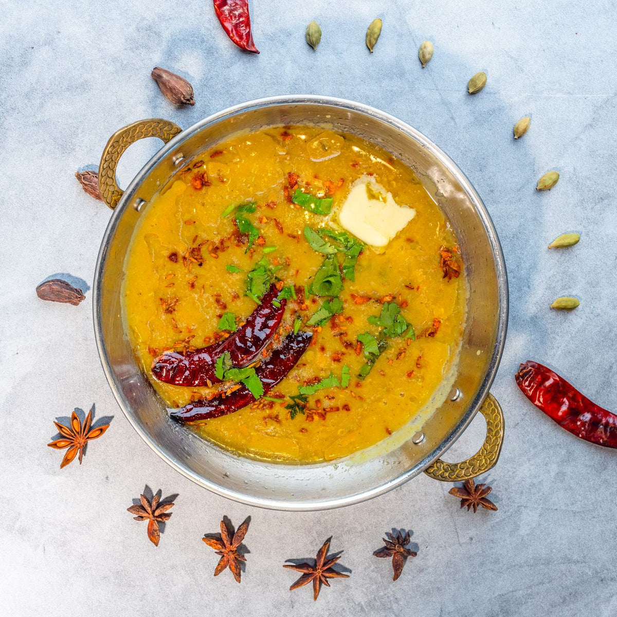 Dal tadka in a brass bowl, a common way to use methi seeds